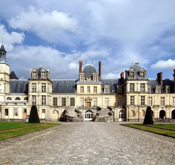 Façade principale du château de Fontainebleau sous ciel nuageux