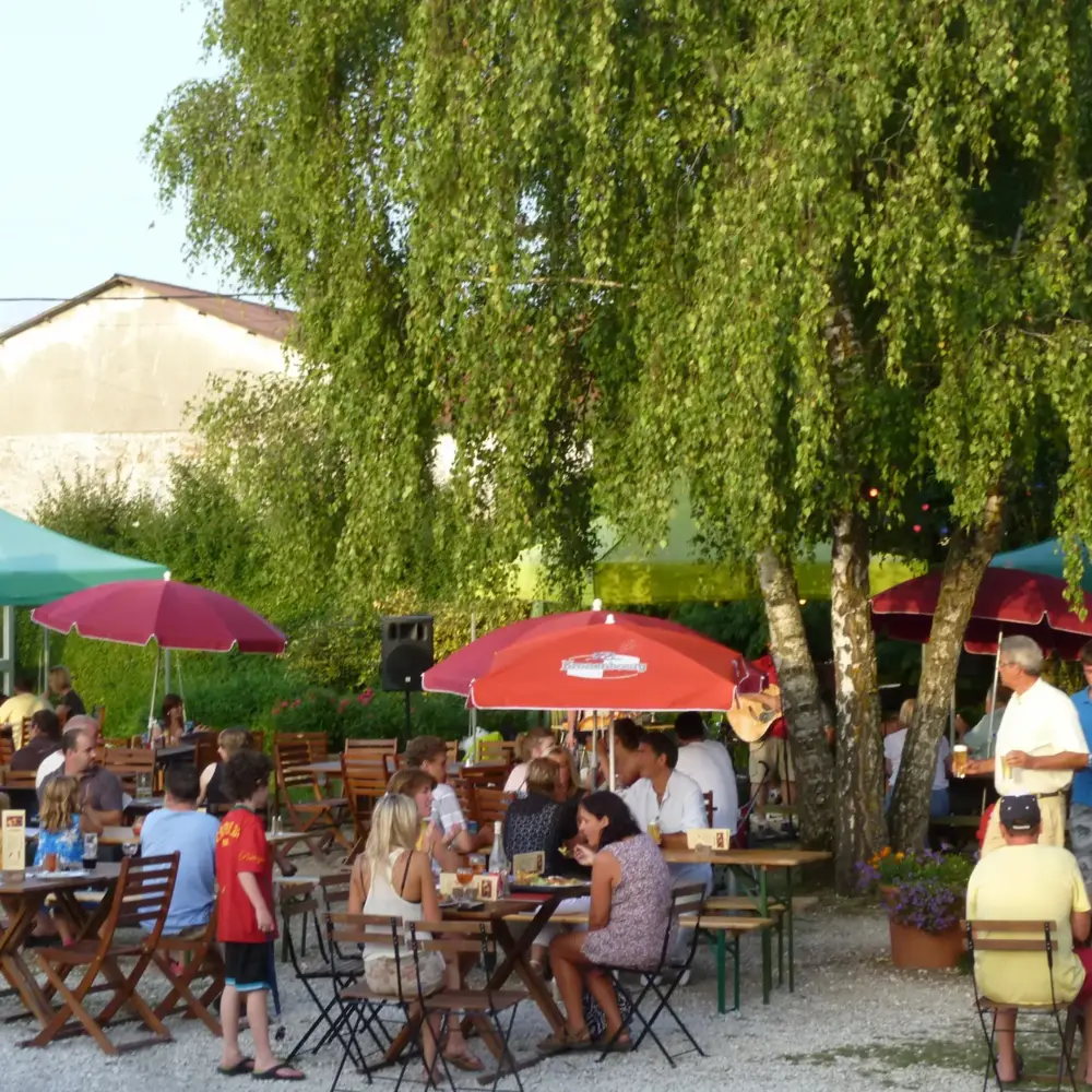 Terrasse animée en été avec familles sous parasols colorés
